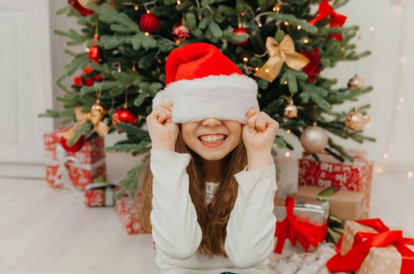 happy-little-girl-santa-claus-hat-near-christmas-tree-child-pulled-new-year-s-hat-his-eyes_132375-6369.jpg